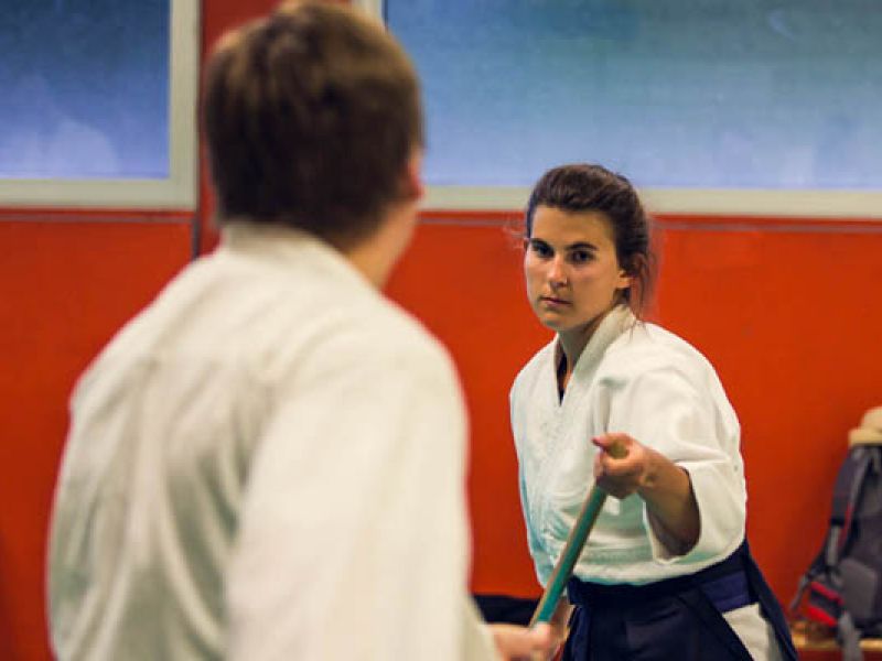 eine Frau mit Stock und ein Mann beim Training