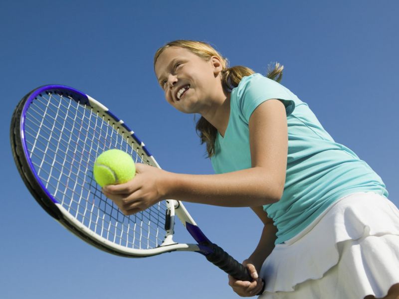 Junge Spielerin beim Aufschlag im Tennis Schläger in der rechten Ball in der linken Hand