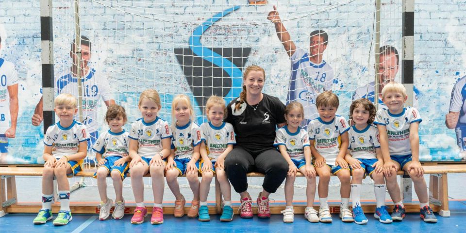 Jugend-Handballteam des SV Kornwestheim jubelt gemeinsam mit Trainerin in der Sporthalle.