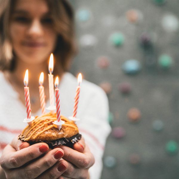 Kindergeburtstag Mädchen mit Brownie mit 5  Kerzen in der Hand