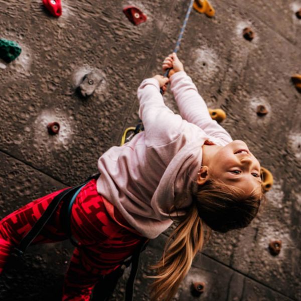Mädchen hat Kletterspass an der Kletterwand